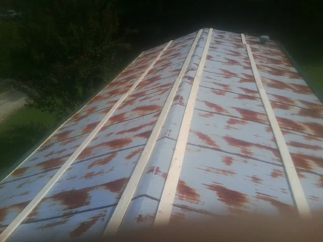 Rusted metal roof panels with new wood purlins before replacement — Storm Damage Roof Repair in Comstock Park by Roofing Brothers